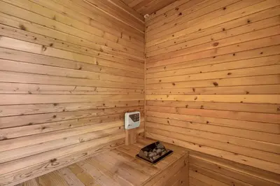 a wooden room with a stove in the corner of a sauna at All-White Villa with Pool, Sauna, Firepit & Office in Jimbaran