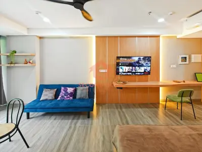 a living room with a blue couch and a table at Lavaya Resort 1BR Nusa Dua with Pool, WiFi, Netflix by 2ndHome in Nusa Dua