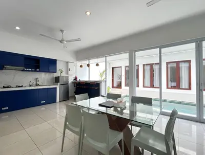 a kitchen and dining room with a glass table and chairs at Mango Villa Seminyak in Kerobokan