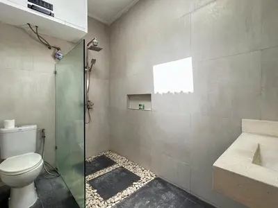 a bathroom with a toilet and a glass shower at Mango Villa Seminyak in Kerobokan