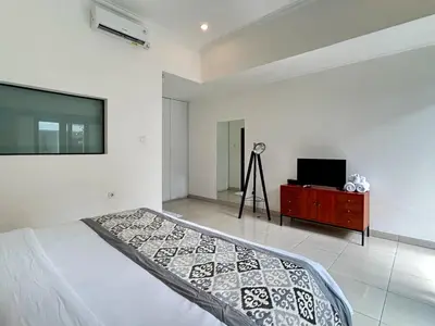 a bedroom with a bed and a flat screen tv at Mango Villa Seminyak in Kerobokan