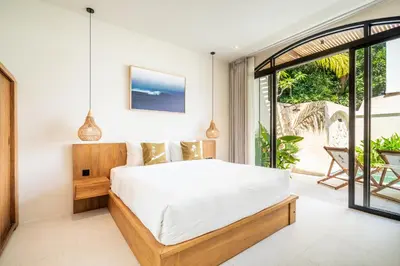 a bedroom with a bed and a balcony at Kuta Beach Villas by Great Bali Villas in Badung