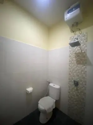 a bathroom with a white toilet and a shower at P Hotel Kuta-3minutes to the beach by Micky Studio in Legian