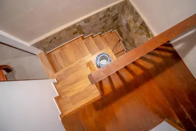 an overhead view of a wooden stairs with a clock at The Sundara Room in Kerobokan