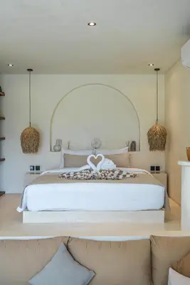 a bedroom with a large white bed with two couches at Villa Luuma 3 - Cozy Umalas Oasis, 1BR Private Villa in Canggu