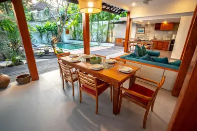a dining room with a wooden table and chairs at The Padma Room in Kerobokan
