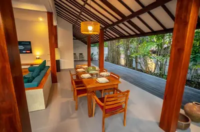 a living room with a wooden table and chairs at The Padma Room in Kerobokan