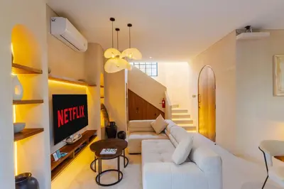 a living room with a white couch and a tv at Villa San Miguel by Pertama Management in Seminyak