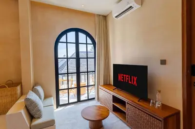 a living room with a tv and a window at Villa San Miguel by Pertama Management in Seminyak