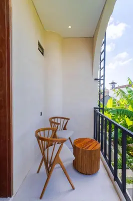 a balcony with two chairs and a table at Villa San Miguel by Pertama Management in Seminyak