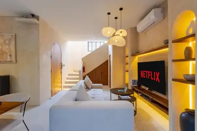 a living room with a white couch and a tv at Villa Santa Clara by Pertama Management in Seminyak