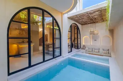 a swimming pool in a house with a tub and windows at Villa Santa Clara by Pertama Management in Seminyak
