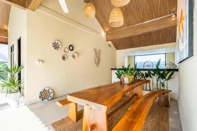 a dining room with a wooden table and plants at The Hijau Damai Villa in Seminyak