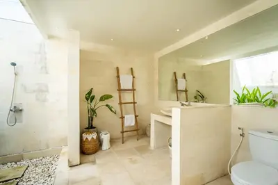 a bathroom with a toilet and a sink and a mirror at The Hijau Damai Villa in Seminyak