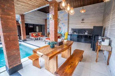 a living room with a table and a swimming pool at Villa jepun berawa in Canggu