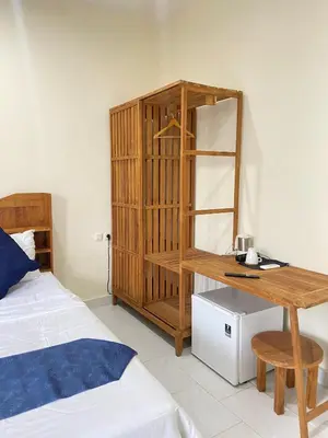 a bedroom with a wooden desk next to a bed at SH Hotel - 20 Second to the Bach by Micky Studio R in Legian