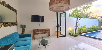 a living room with a blue couch and a glass table at Villa TJ Subali 3 BR privatepool close to Seminyak in Seminyak