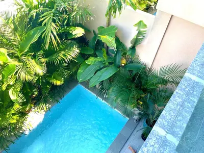 an overhead view of a swimming pool with palm trees at DUNE Villas in Seminyak