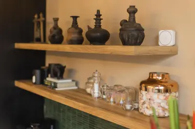 a shelf with vases and other items on it at DUNE Villas in Seminyak