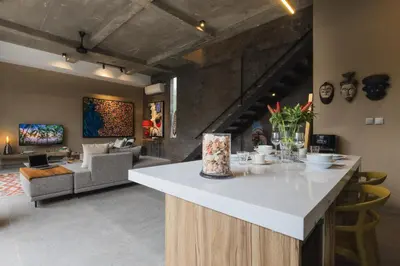 a kitchen with a counter and a living room at DUNE Villas in Seminyak