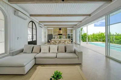 a living room with a large couch and a dining room at Villa Aclasa Luxery 4BR Retreat in Berawa, Canggu in Canggu
