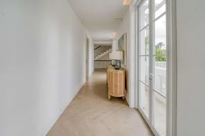 a hallway with white walls and a floor to ceiling window at Villa Aclasa Luxery 4BR Retreat in Berawa, Canggu in Canggu