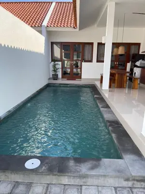 a swimming pool in the middle of a house at Villa Cassia Jimbaran in Jimbaran