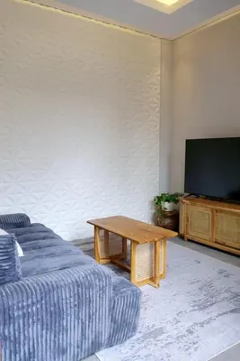 a living room with a couch and a table and a tv at Villa Mannah - Managed By Chayah Bali Villa Group in Kuta