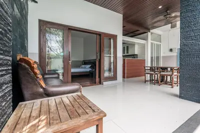 a living room with a bench and a bedroom at Villa Nakula - Managed By Chayah Bali Villa Group in Seminyak
