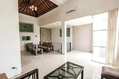 a living room with a glass table and a couch at Villa Nakula - Managed By Chayah Bali Villa Group in Seminyak
