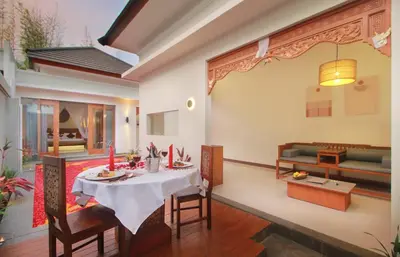 a dining room and living room with a table and chairs at Maharaja Villas Seminyak by Humus Hospitality in Kerobokan