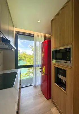 a red refrigerator in a kitchen with a window at MODERN 2 BEDROOM LAVAYA OAKWOOD APARTMENT, Nusa Dua in Nusa Dua