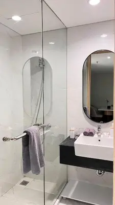 a bathroom with a shower and a sink and a mirror at MODERN 2 BEDROOM LAVAYA OAKWOOD APARTMENT, Nusa Dua in Nusa Dua
