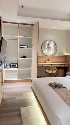 a bedroom with a bed and a table and a mirror at MODERN 2 BEDROOM LAVAYA OAKWOOD APARTMENT, Nusa Dua in Nusa Dua