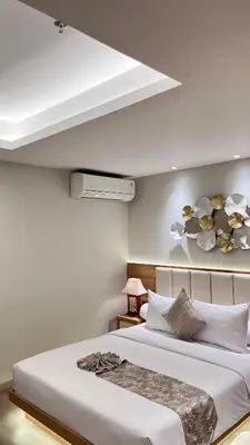 a bedroom with a large white bed with flowers on the wall at MODERN 2 BEDROOM LAVAYA OAKWOOD APARTMENT, Nusa Dua in Nusa Dua