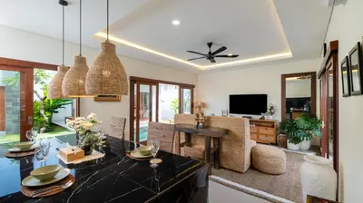 a living room with a dining table and a television at The Lange Estate in Seminyak