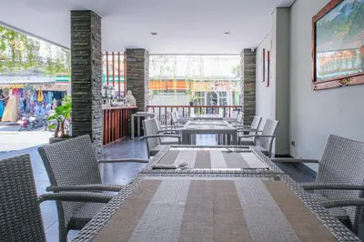 a long table and chairs on a balcony with a table and chairsktop at Kamini Legian Hotel in Legian