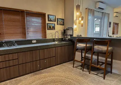 a kitchen with two bar stools and a sink at Tropical Townhouse 3 Bedrooms Seminyak in Seminyak