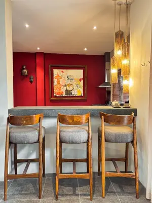 a kitchen with a bar with two stools at Tropical Townhouse 3 Bedrooms Seminyak in Seminyak