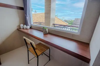 a table and a chair in a room with a window at Homely Bali at Seminyak in Kerobokan