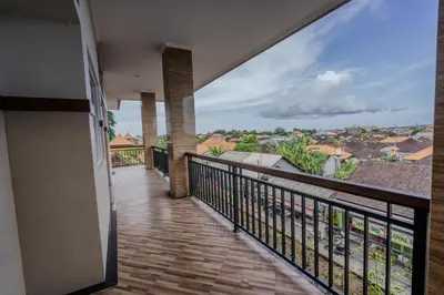 a balcony with a view of the ocean at Homely Bali at Seminyak in Kerobokan