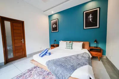 a bedroom with a bed and a blue wall at Peaceful private 3BR pool villa in heart of Bali in Legian