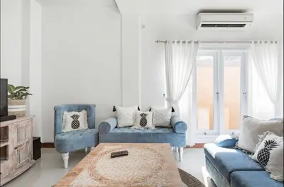 a living room with two blue chairs and a table at Walk to Beach - Private 3 Bedroom Villa Roshi Seminyak in Seminyak