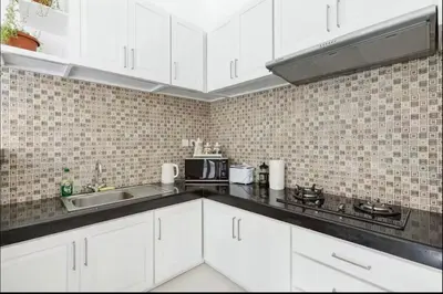 a kitchen with white cabinets and a sink at Walk to Beach - Private 3 Bedroom Villa Roshi Seminyak in Seminyak