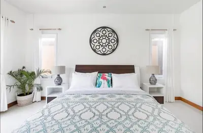 a white bedroom with a large bed and two windows at Walk to Beach - Private 3 Bedroom Villa Roshi Seminyak in Seminyak
