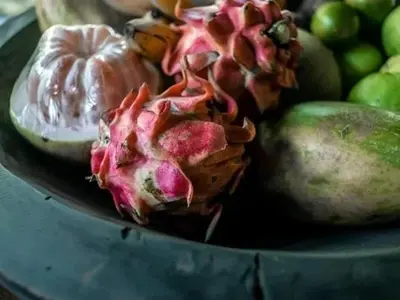 a bowl of fruit with a pineapple and other fruits at My secret home ( full villa) in Seminyak