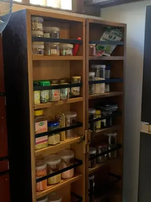 a pantry with wooden shelves filled with food at My secret home ( full villa) in Seminyak