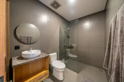 a bathroom with a sink and a toilet and a mirror at Mirragold Villa - Sun, Pool and Views - Brand New 3BDR Villa in Kerobokan