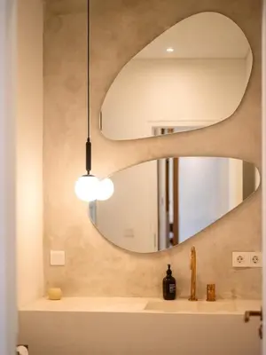 a bathroom with a round mirror over a sink at Berawa Luxury Retreat - The Cruise Canggu in Canggu