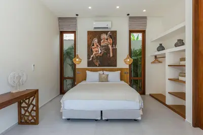 a bedroom with a bed and a desk and shelves at Villa Trindade 5BR, 15m Pool in Seminyak